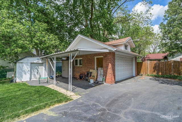 view of front of house featuring brick siding, a storage unit, a detached garage, and an outbuilding