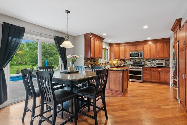 384 Edgewater Ct, Sugar Grove, IL 60554 - kitchen featuring stainless steel appliances, dark countertops, tasteful backsplash, light wood-type flooring, and brown cabinets