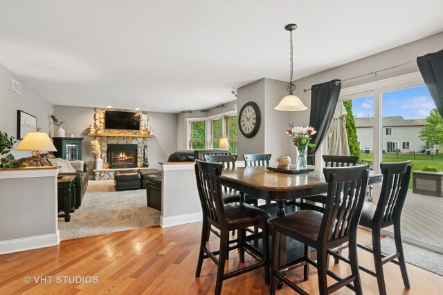 384 Edgewater Ct, Sugar Grove, IL 60554 - dining area featuring light wood-style floors, a fireplace, and baseboards