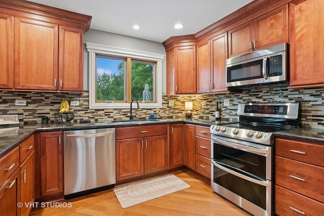 384 Edgewater Ct, Sugar Grove, IL 60554 - kitchen with appliances with stainless steel finishes, a sink, light wood-type flooring, decorative backsplash, and dark stone counters