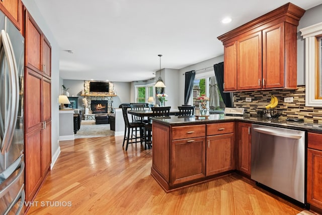 384 Edgewater Ct, Sugar Grove, IL 60554 - kitchen with stainless steel appliances, light wood finished floors, a peninsula, backsplash, and open floor plan