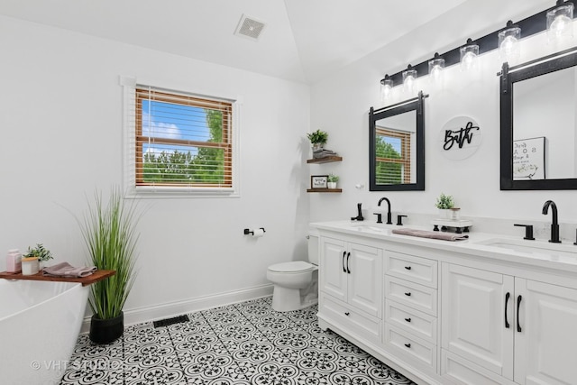 384 Edgewater Ct, Sugar Grove, IL 60554 - bathroom featuring double vanity, vaulted ceiling, baseboards, a freestanding bath, and toilet