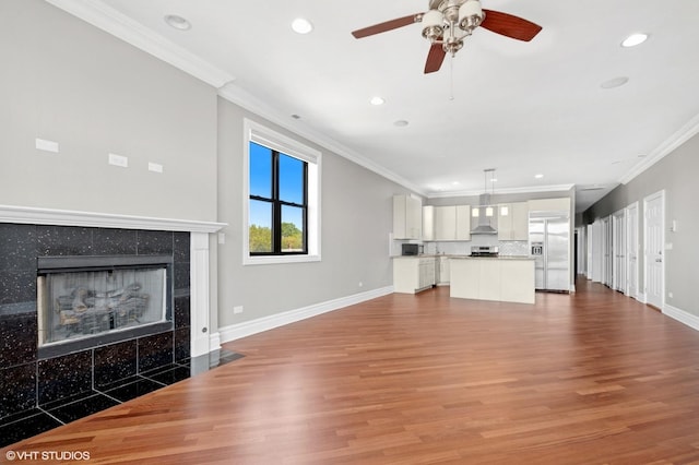 unfurnished living room featuring crown molding, baseboards, recessed lighting, wood finished floors, and a fireplace