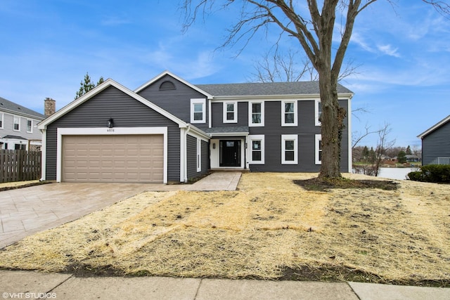 view of front of house with a garage, fence, and concrete driveway