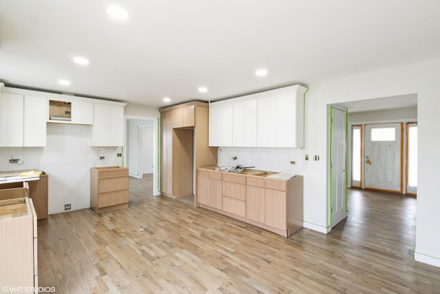 kitchen with light wood-type flooring, recessed lighting, white cabinetry, light brown cabinets, and baseboards