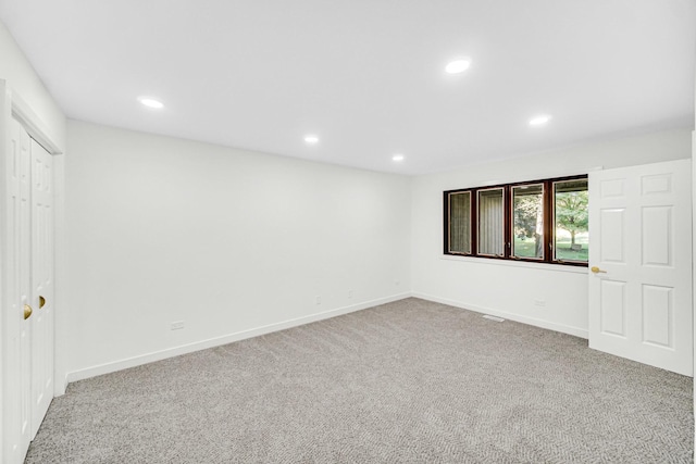 carpeted spare room featuring recessed lighting and baseboards