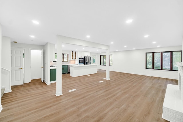 unfurnished living room featuring light wood finished floors, baseboards, and recessed lighting