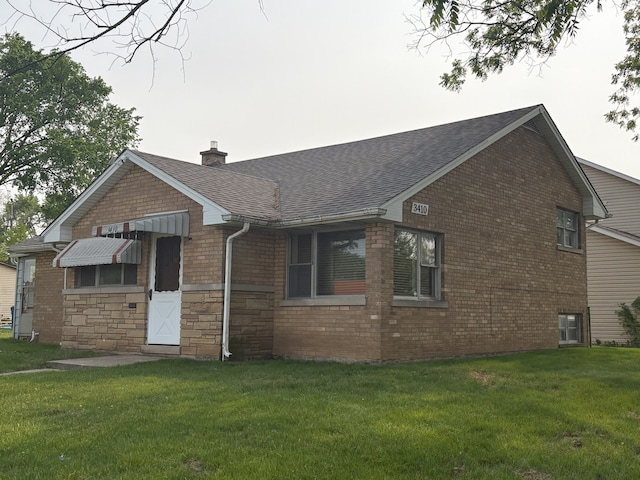 3410 Calwagner St, Franklin Park, IL 60131 - rear view of property featuring a shingled roof, a lawn, a chimney, brick siding, and stone siding
