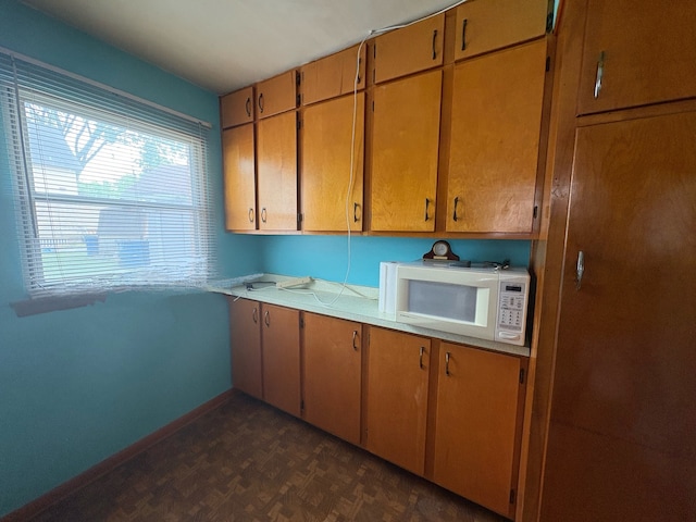 3410 Calwagner St, Franklin Park, IL 60131 - kitchen featuring white microwave, light countertops, baseboards, and brown cabinets