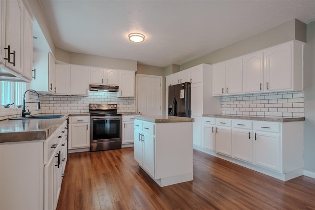 kitchen featuring electric range, a sink, black refrigerator with ice dispenser, under cabinet range hood, and tasteful backsplash