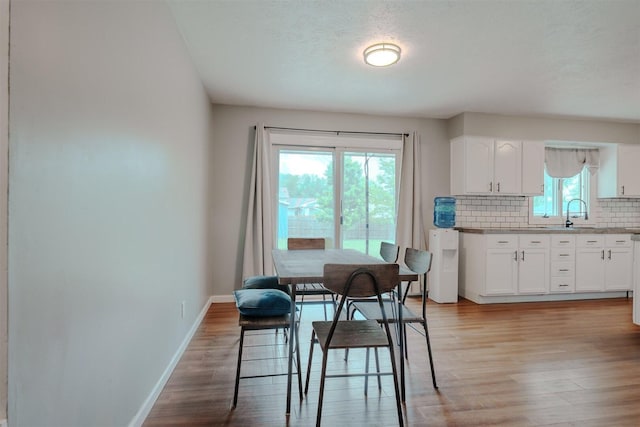 dining area featuring light wood-style floors and baseboards