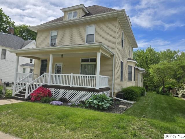 722 Wabash Ave, Carthage, IL 62321 - american foursquare style home with a porch and a front lawn