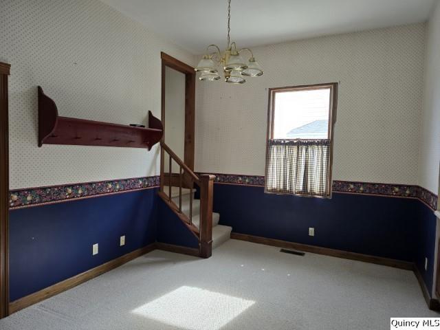 722 Wabash Ave, Carthage, IL 62321 - unfurnished dining area with a chandelier, wallpapered walls, and stairway