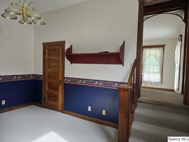 722 Wabash Ave, Carthage, IL 62321 - carpeted empty room with wallpapered walls, a chandelier, and baseboards