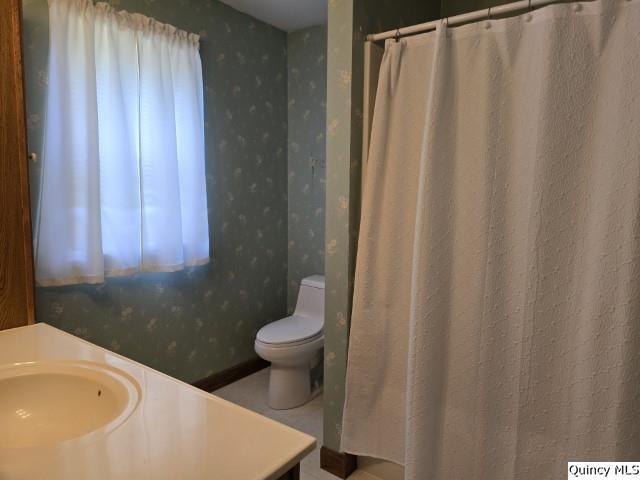 722 Wabash Ave, Carthage, IL 62321 - full bathroom featuring wallpapered walls, toilet, vanity, and curtained shower