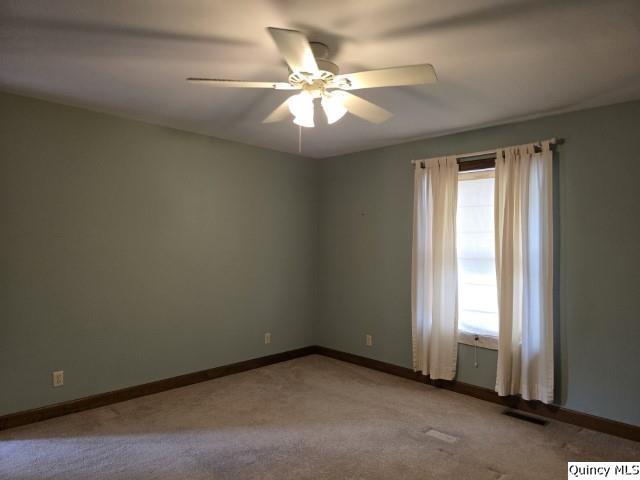 722 Wabash Ave, Carthage, IL 62321 - empty room featuring a ceiling fan, carpet flooring, and baseboards