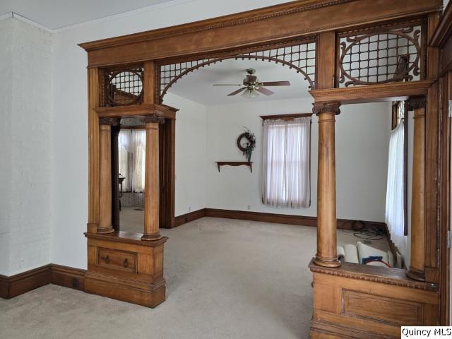722 Wabash Ave, Carthage, IL 62321 - unfurnished living room featuring carpet floors, a ceiling fan, baseboards, and arched walkways
