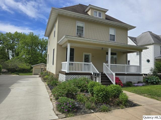 722 Wabash Ave, Carthage, IL 62321 - american foursquare style home with covered porch, an outdoor structure, and a detached garage