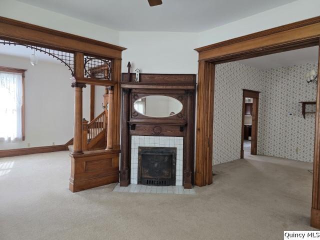 722 Wabash Ave, Carthage, IL 62321 - unfurnished living room featuring carpet floors, a tiled fireplace, stairway, and ceiling fan