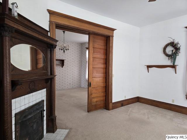 722 Wabash Ave, Carthage, IL 62321 - unfurnished living room with light carpet, a chandelier, a tile fireplace, and baseboards