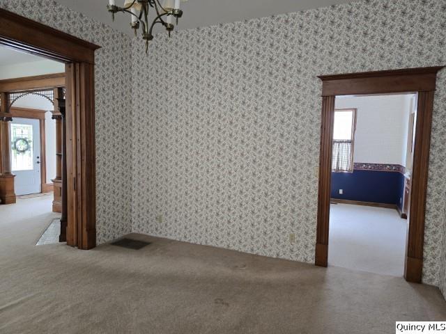 722 Wabash Ave, Carthage, IL 62321 - unfurnished room with a chandelier, carpet, plenty of natural light, and wallpapered walls