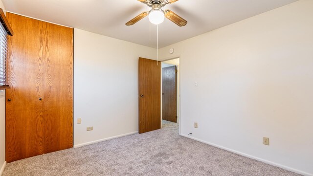 unfurnished bedroom with carpet, baseboards, and a ceiling fan