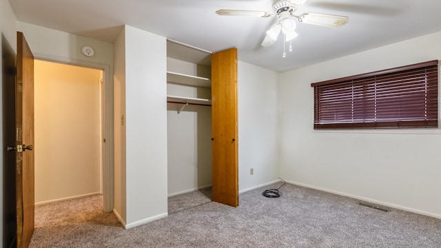 unfurnished bedroom featuring carpet flooring, a closet, baseboards, and a ceiling fan