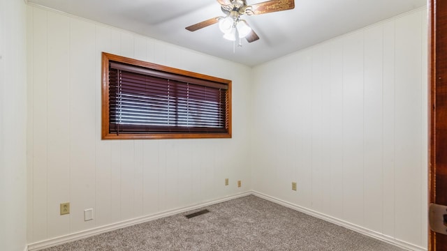 carpeted empty room with a ceiling fan and crown molding