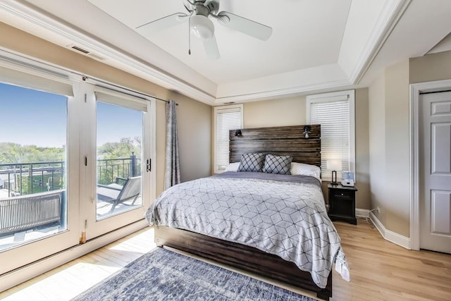 bedroom featuring light wood-style flooring, access to outside, baseboards, ceiling fan, and a raised ceiling