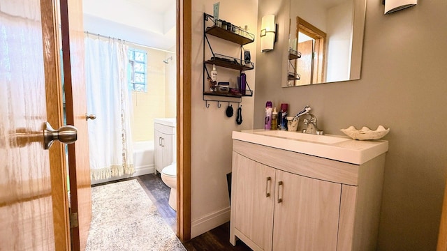 full bathroom featuring toilet, wood finished floors, vanity, shower / bath combo with shower curtain, and baseboards