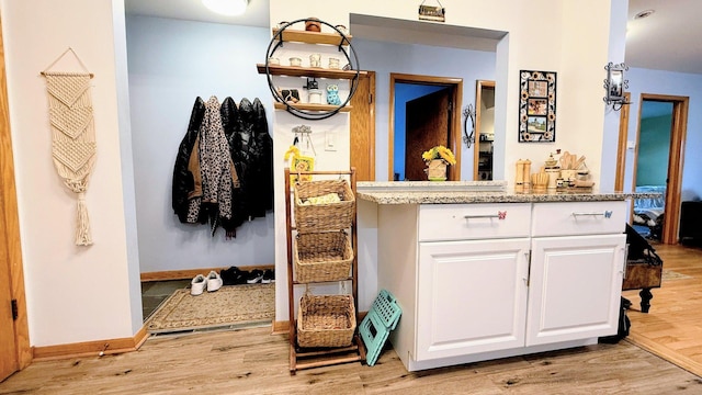 ensuite bathroom featuring wood finished floors, baseboards, and vanity