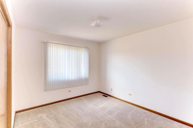 unfurnished room featuring baseboards and carpet