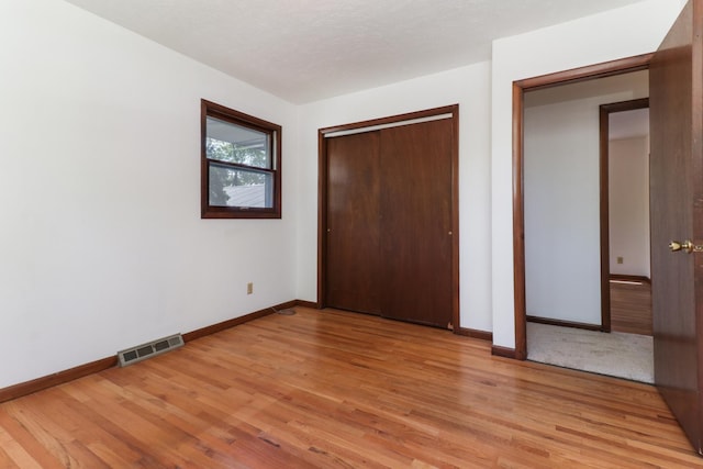 311 Hillside Ln, Bloomington, IL 61701 - unfurnished bedroom featuring light wood-style floors, baseboards, and a closet