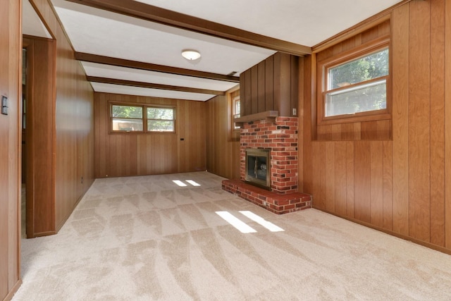 311 Hillside Ln, Bloomington, IL 61701 - unfurnished living room with beam ceiling, light carpet, a fireplace, and wood walls