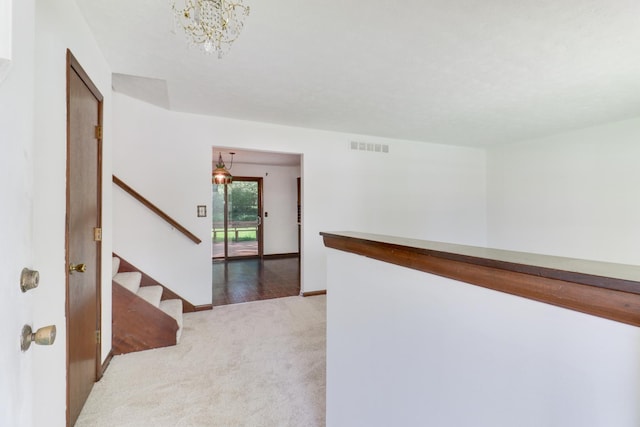 311 Hillside Ln, Bloomington, IL 61701 - corridor featuring light carpet, a chandelier, stairs, and baseboards