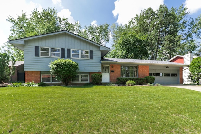 311 Hillside Ln, Bloomington, IL 61701 - tri-level home with brick siding, a garage, a front lawn, and concrete driveway