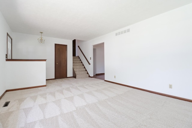 311 Hillside Ln, Bloomington, IL 61701 - empty room with stairway, light carpet, baseboards, and a chandelier