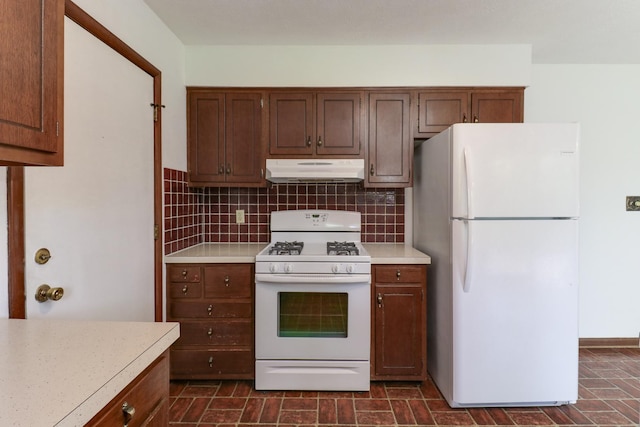 311 Hillside Ln, Bloomington, IL 61701 - kitchen featuring white appliances, under cabinet range hood, light countertops, and tasteful backsplash