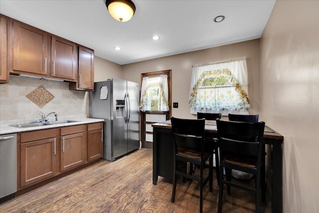 1264 N Kennedy Dr, Streamwood, IL 60107 - kitchen featuring stainless steel appliances, a sink, light wood-type flooring, light countertops, and tasteful backsplash