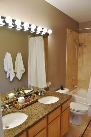 full bathroom featuring toilet, shower / tub combo, and double vanity