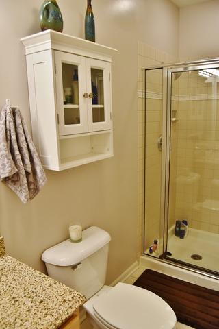 full bathroom with toilet, a stall shower, and vanity