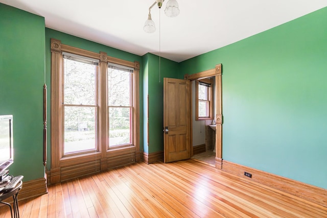 706 Washington Ave, Dixon, IL 61021 - empty room featuring baseboards, healthy amount of natural light, and light wood finished floors