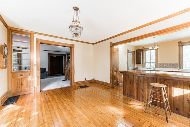 706 Washington Ave, Dixon, IL 61021 - kitchen featuring a chandelier, light wood-style floors, baseboards, hanging light fixtures, and crown molding