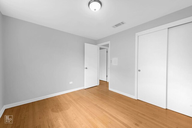 6758 W 64th Pl Unit 13, Chicago, IL 60638 - unfurnished bedroom with light wood-style floors, baseboards, and a closet
