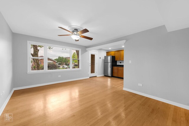 6758 W 64th Pl Unit 13, Chicago, IL 60638 - unfurnished living room with a ceiling fan, light wood finished floors, and baseboards