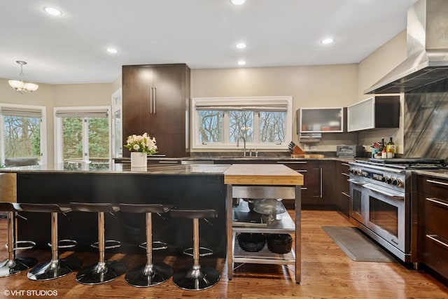 122 Ravine Ln, Barrington, IL 60010 - kitchen with range with two ovens, wall chimney exhaust hood, healthy amount of natural light, a kitchen bar, and recessed lighting