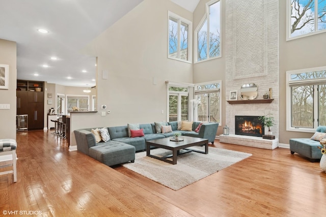 122 Ravine Ln, Barrington, IL 60010 - living room featuring a towering ceiling, wood finished floors, a fireplace, baseboards, and recessed lighting