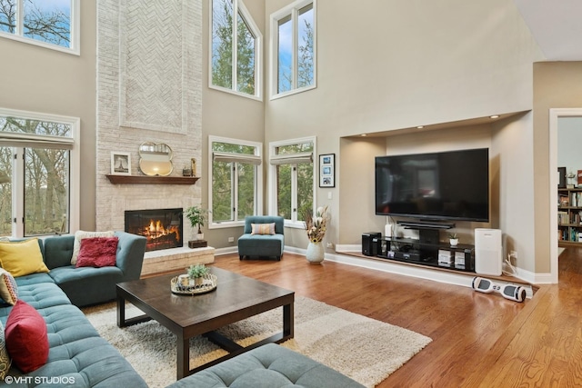 122 Ravine Ln, Barrington, IL 60010 - living room with a towering ceiling, wood finished floors, a brick fireplace, and plenty of natural light