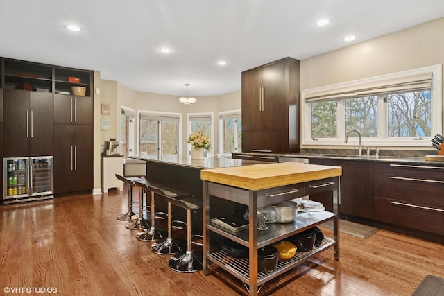 122 Ravine Ln, Barrington, IL 60010 - kitchen with dark brown cabinets, a sink, wood finished floors, modern cabinets, and recessed lighting