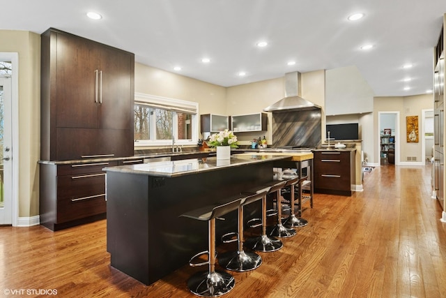 122 Ravine Ln, Barrington, IL 60010 - kitchen with wall chimney range hood, modern cabinets, a center island, a kitchen breakfast bar, and recessed lighting